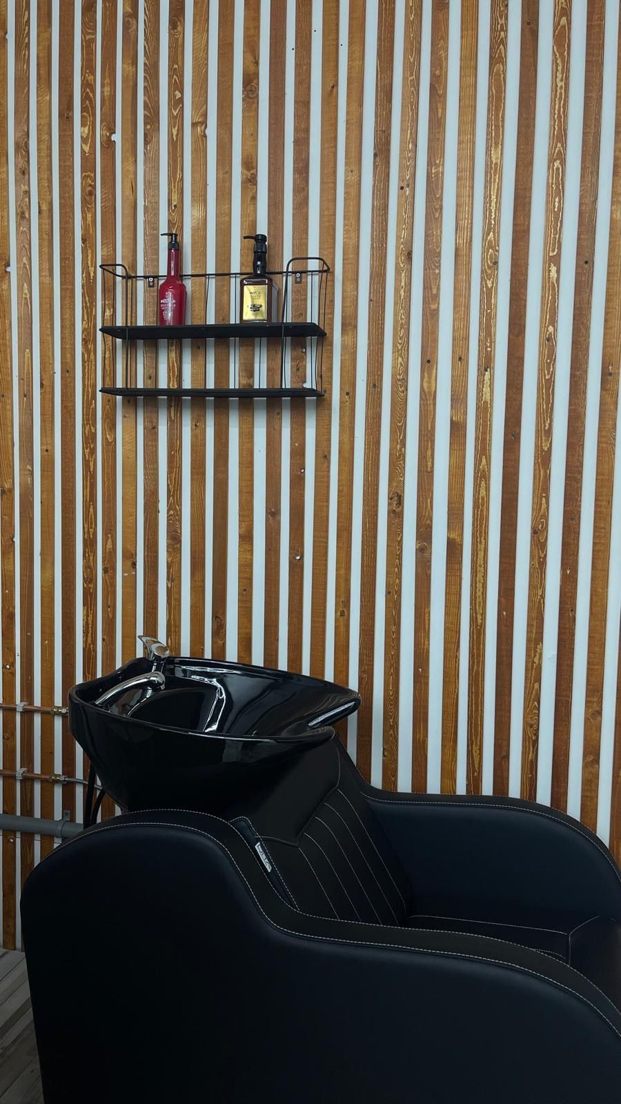 Zwarte wasstoel voor de wand van eiken latten