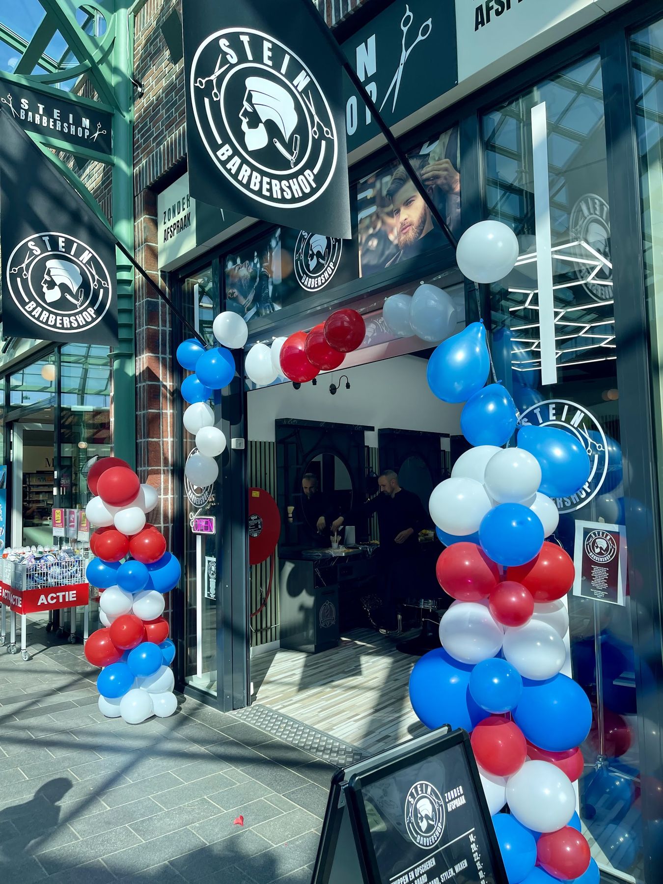 De ingang op de openingsdag, met ballonnen in rood, wit en blauw