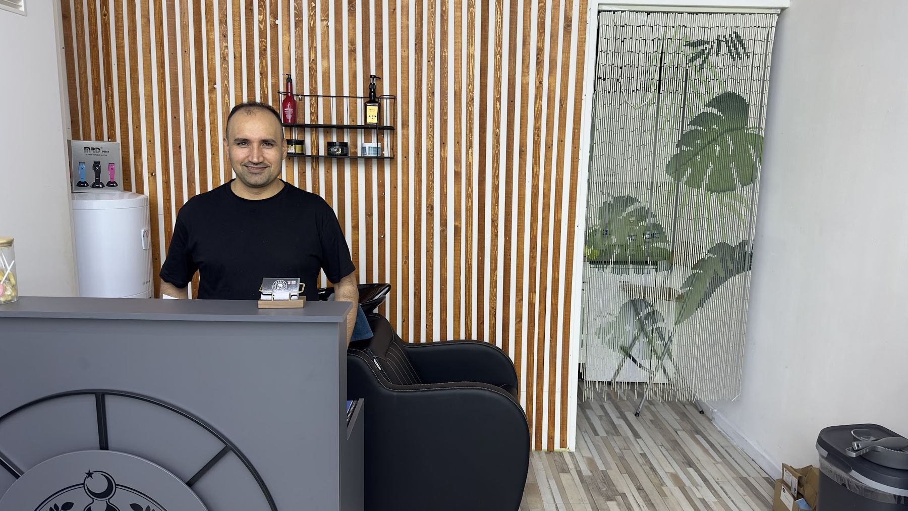 De eigenaar van Stein Barbershop achter de balie